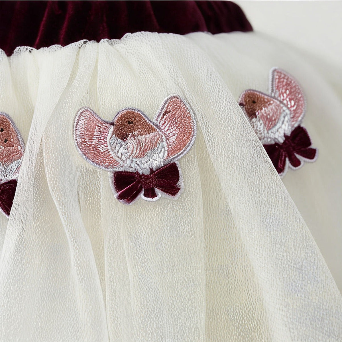 Close up of the embroidered robin appliques and burgundy velvet bows on the Robin Tutu Skirt
