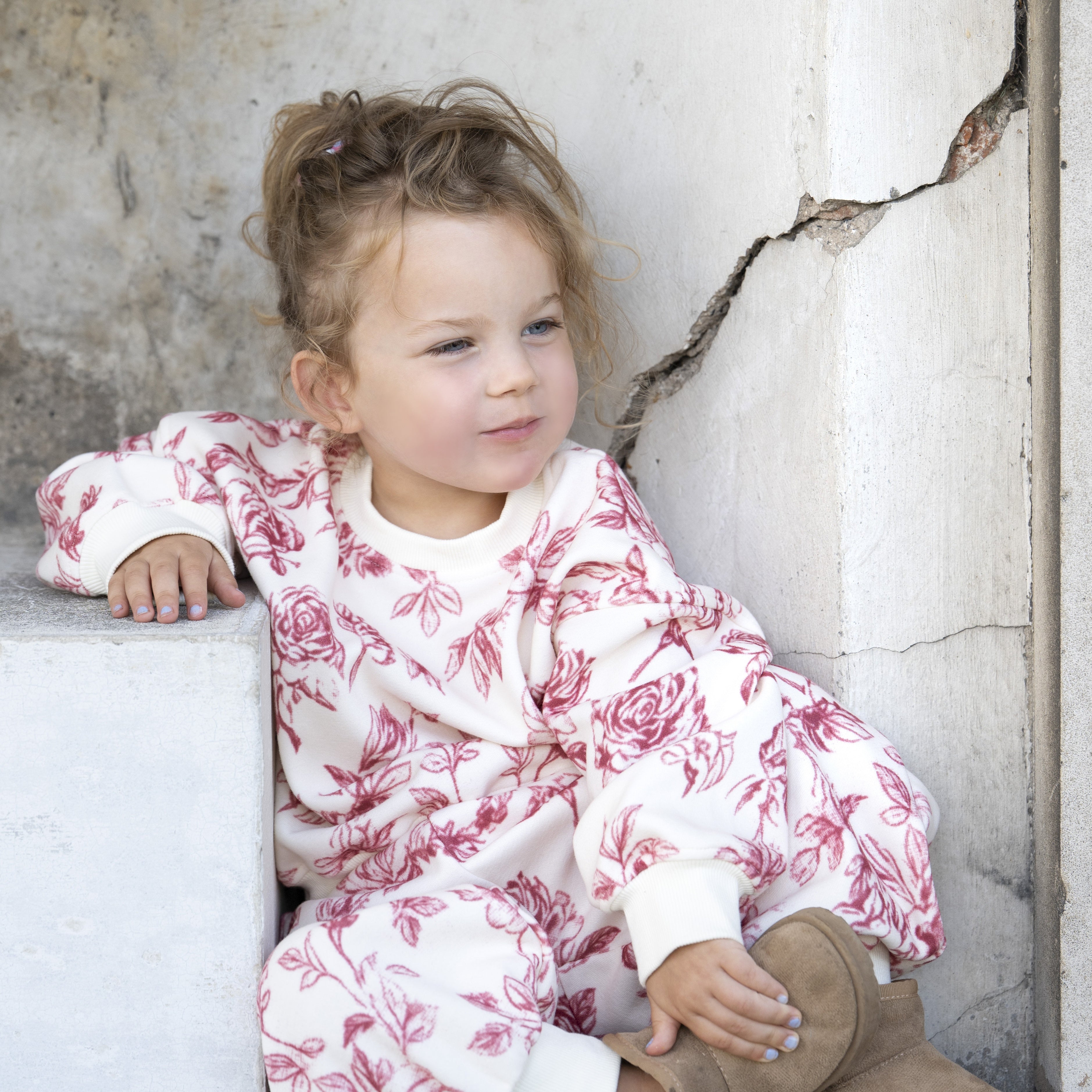 Rose Tracksuit — child sitting wearing the Rose Tracksuit (square)