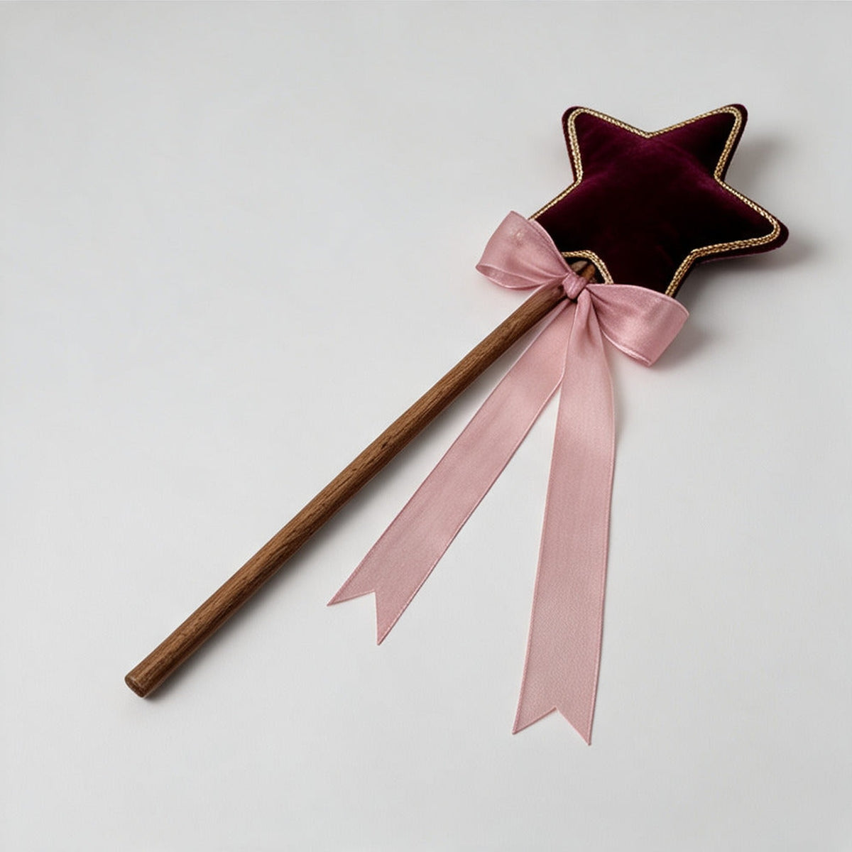Robin Star Wand laid flat, showing the wooden handle and trailing pink satin ribbon bow