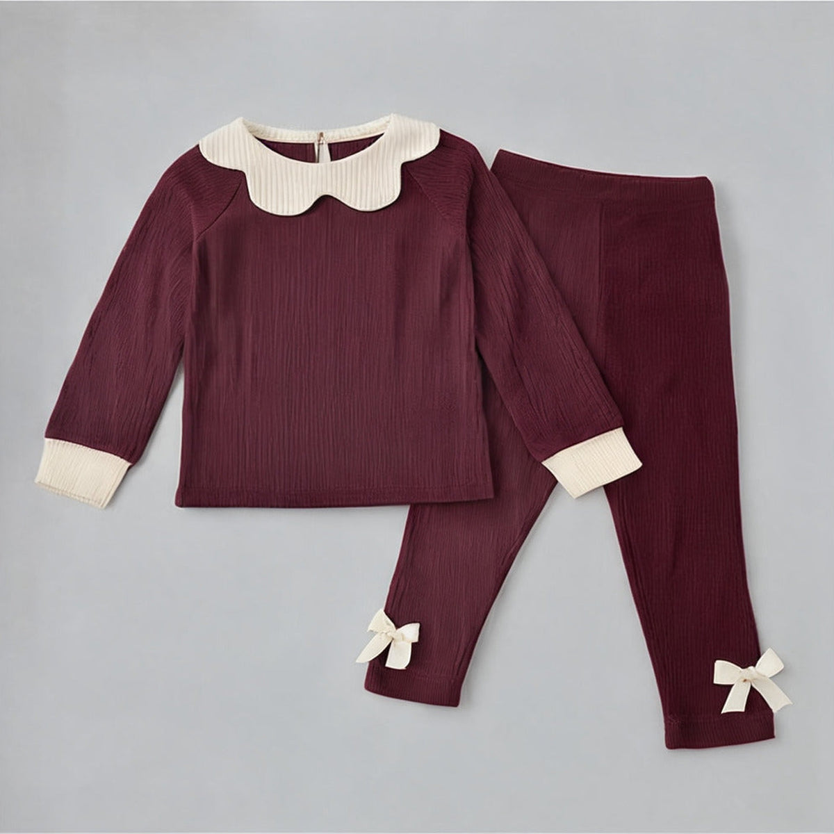 Robin Soft Borg Set in burgundy laid flat, top and leggings with cream bows at the ankle